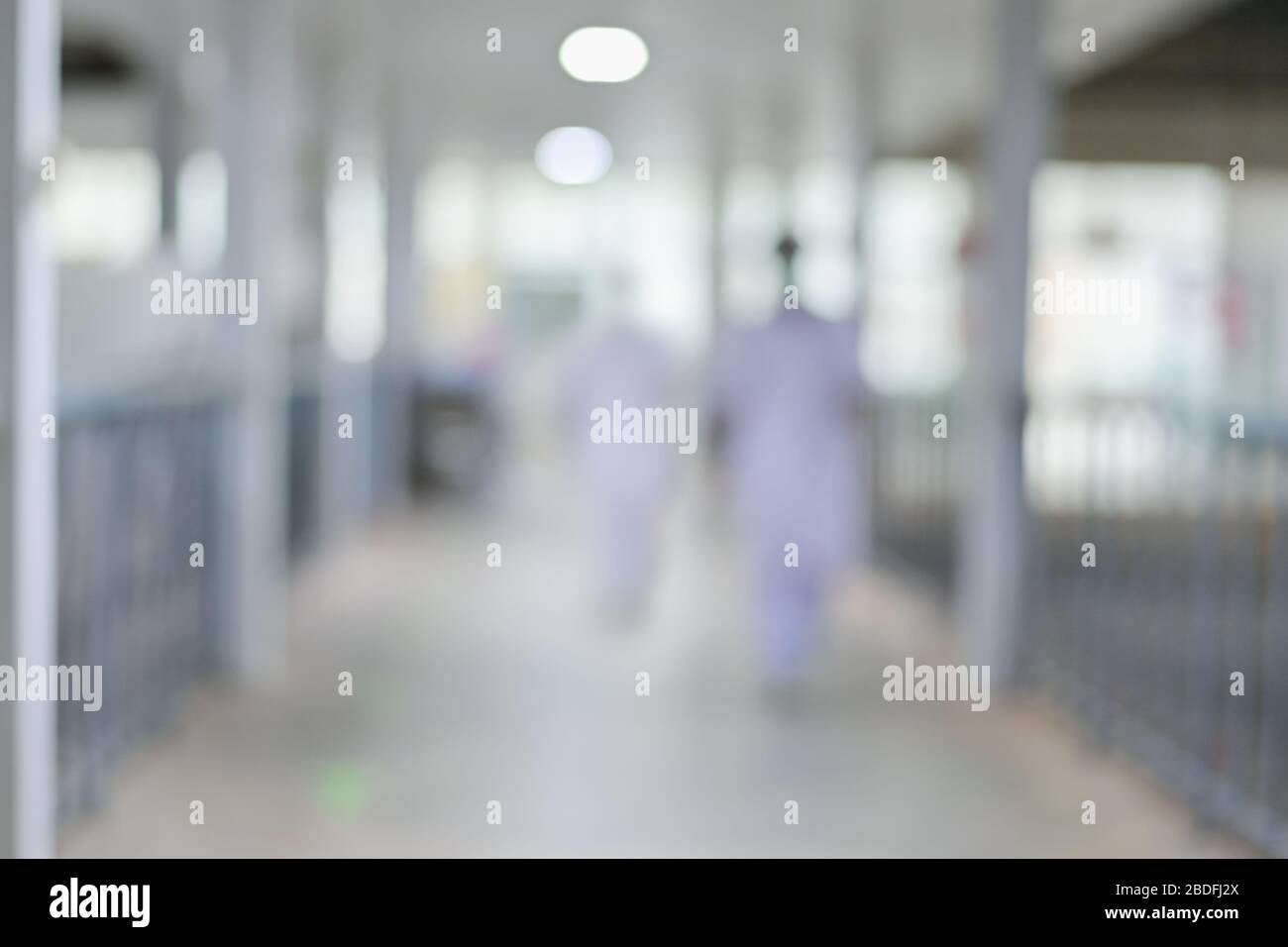 Enfermero y médico borrosos caminando por el pasillo del hospital en la noche, medicina fondo borroso. Foto de stock