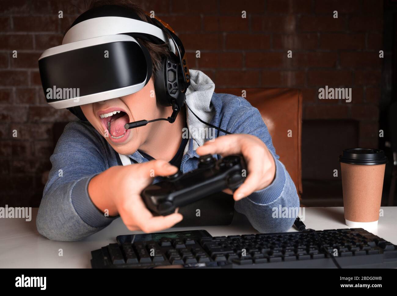 Adolescente en VR y auriculares con micrófono jugando un juego en casa y  streaming. El loco gritó durante su última y más dura batalla Fotografía de  stock - Alamy