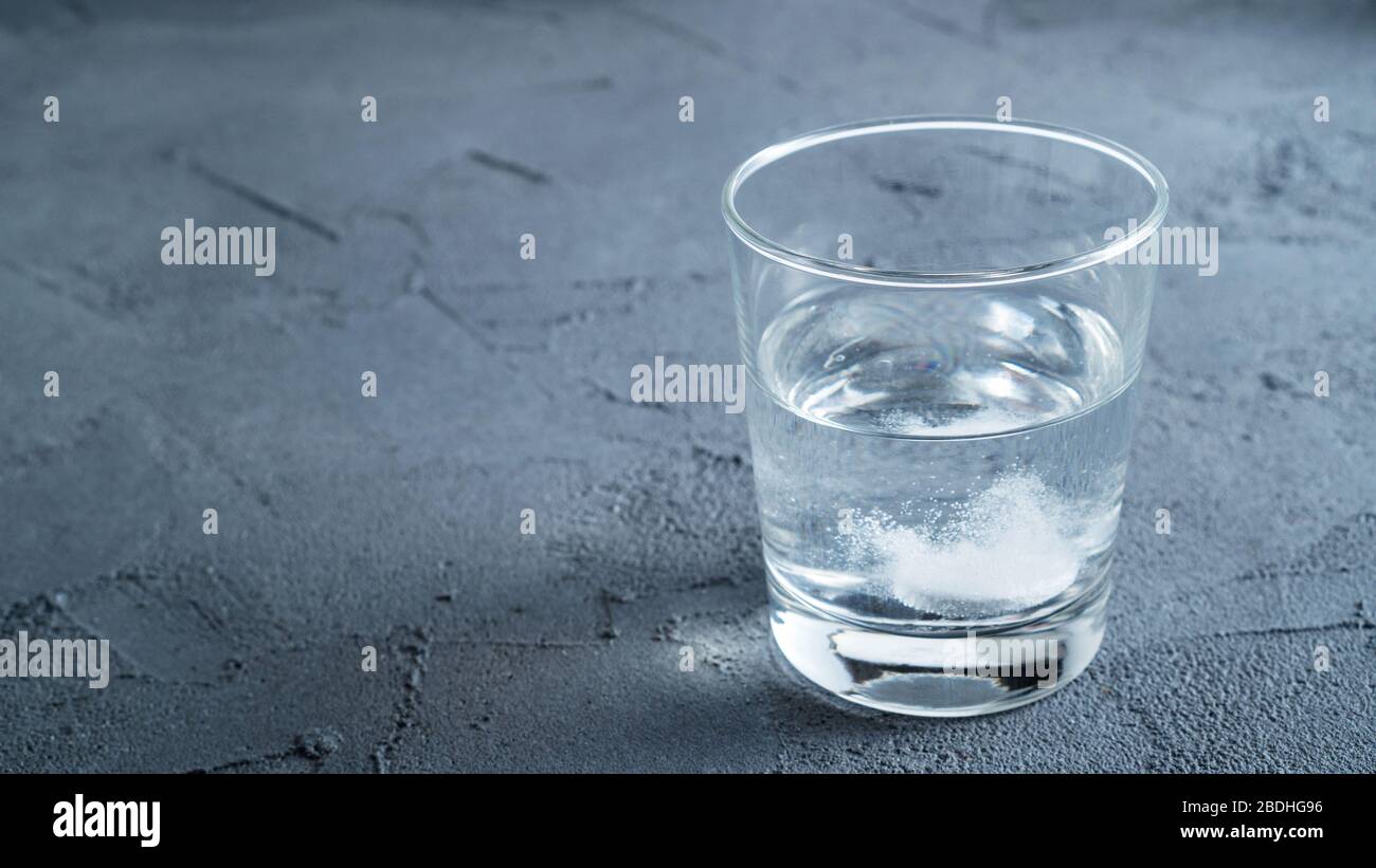 Vaso de agua con una píldora espumosa. Recuperación de un dolor de cabeza Foto de stock