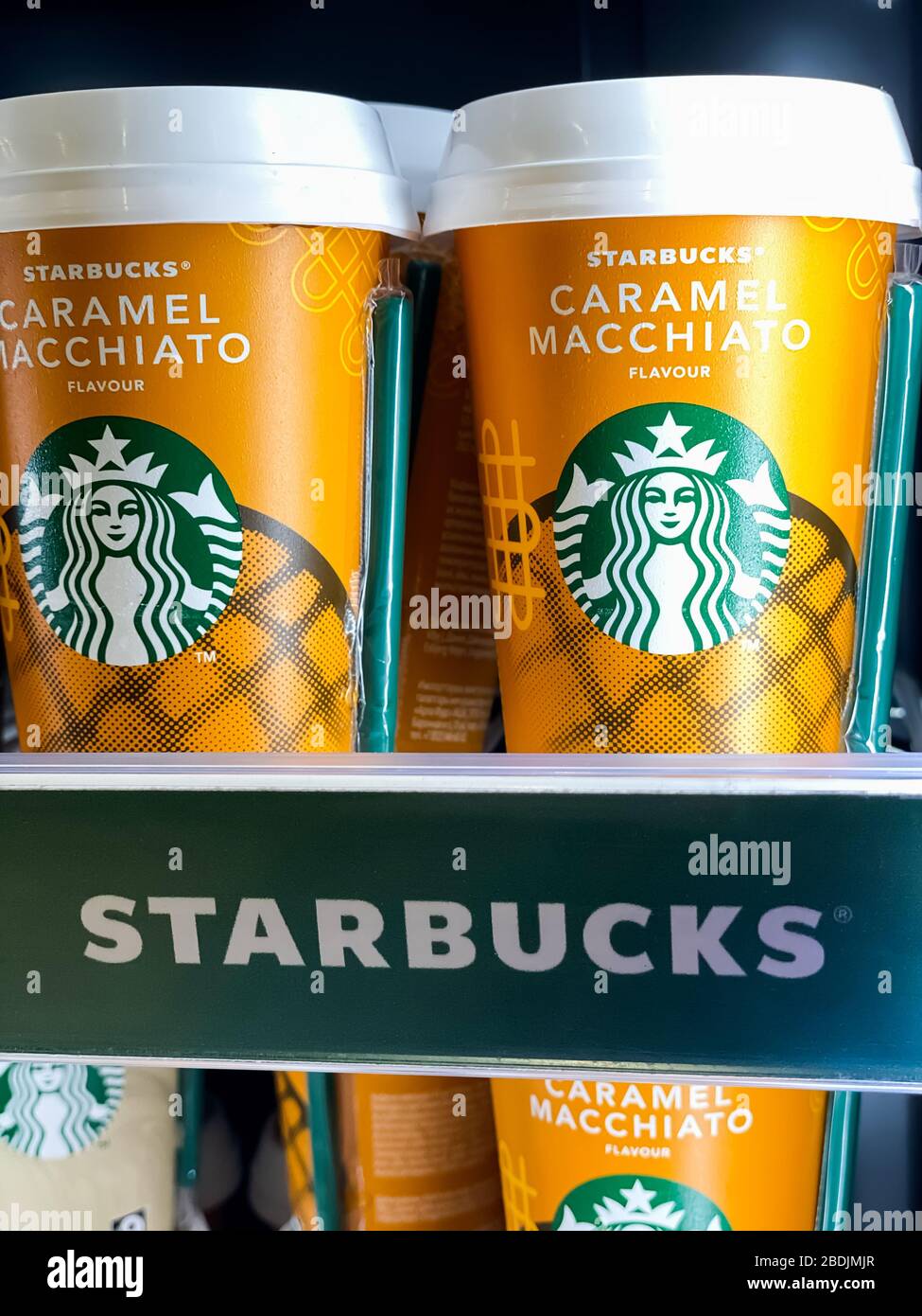 Hay una fila de tazas de café Starbucks listas para ir en un estante de la nevera del supermercado. Fotografía móvil. Moscú, Rusia - 06 de febrero de 2020 Foto de stock