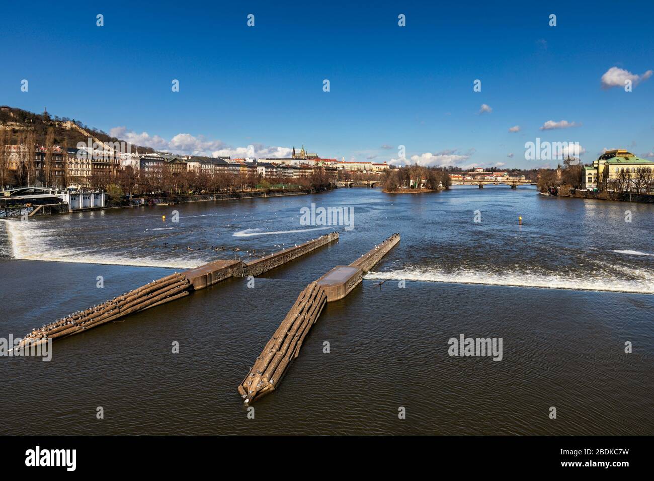 Vista desde el puente Jiraskuv de la presa de hormigón y canales que controlan el flujo de agua en el río Vltava , Jiráskův Most, Praga, República Checa Foto de stock