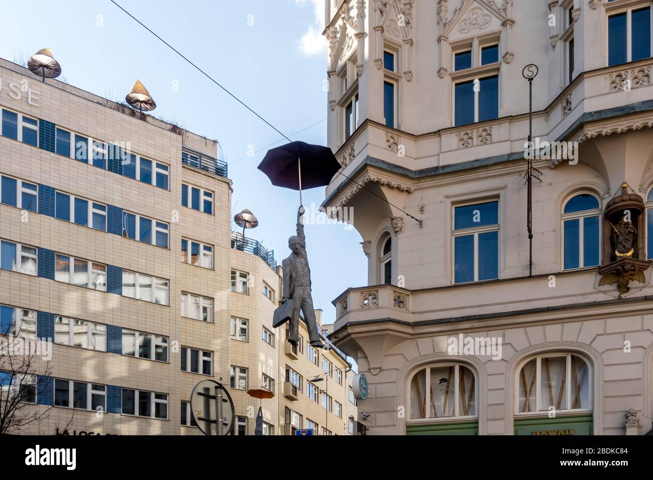 Hombre colgado con escultura de paraguas llamada ligera incertidumbre por Michal Trpak en Nove Mesto, Praga, República Checa Foto de stock