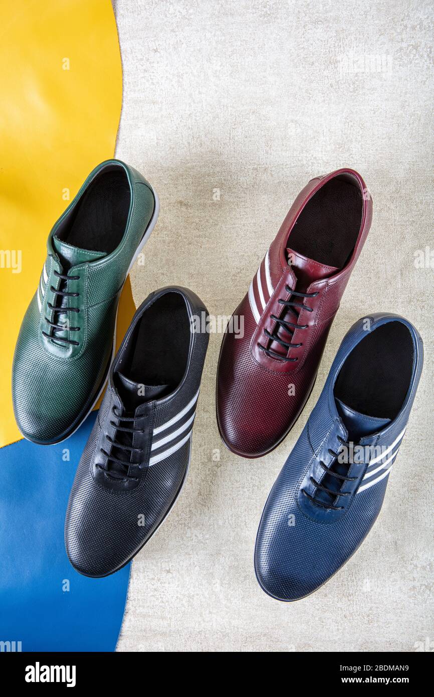 zapatos de cuero hechos a mano en diferentes piezas de cuero de color.  zapatos de moda para hombres se muestran sobre fondo de cuero de color  Fotografía de stock - Alamy