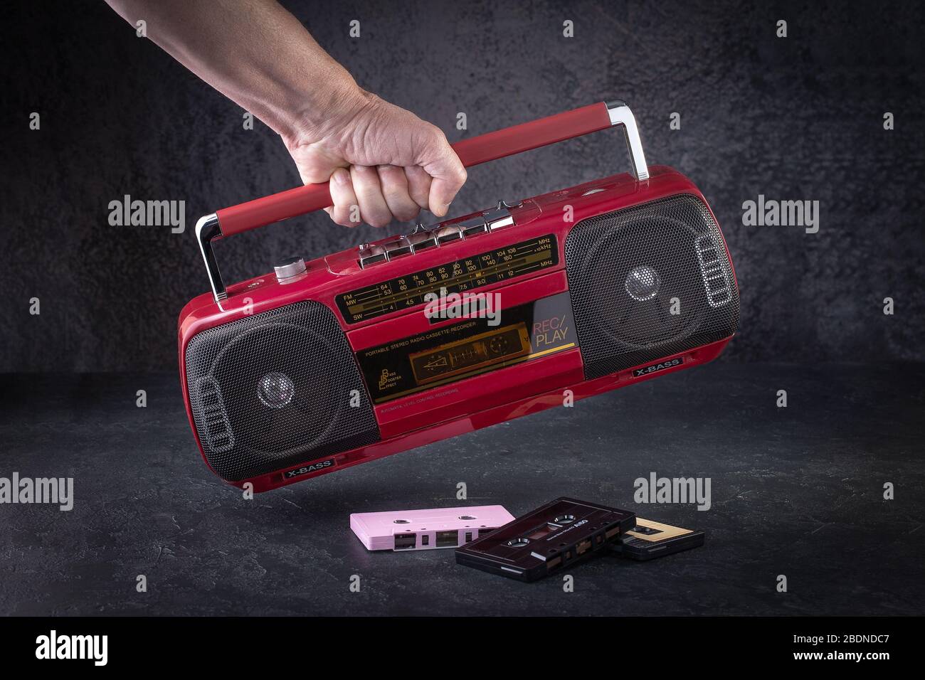 Radiocasete clásico sobre fondo oscuro. Radio roja retro y reproductor de casetes. Tecnología retro Foto de stock