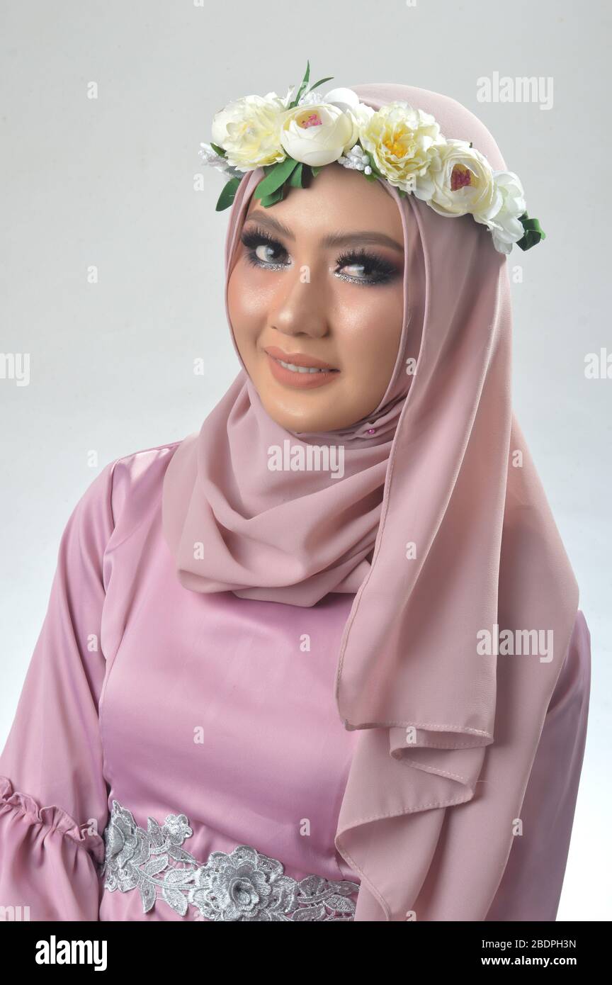 Retrato hermosas chicas musulmanas asiáticas con una camisa musulmana rosa  y una banda de flores, una foto de estudio con un fondo blanco Fotografía  de stock - Alamy