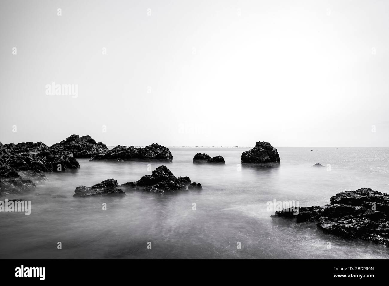 Blanco / negro, hermoso paisaje de rocas en la costa, larga exposición, costa este de Corea Foto de stock