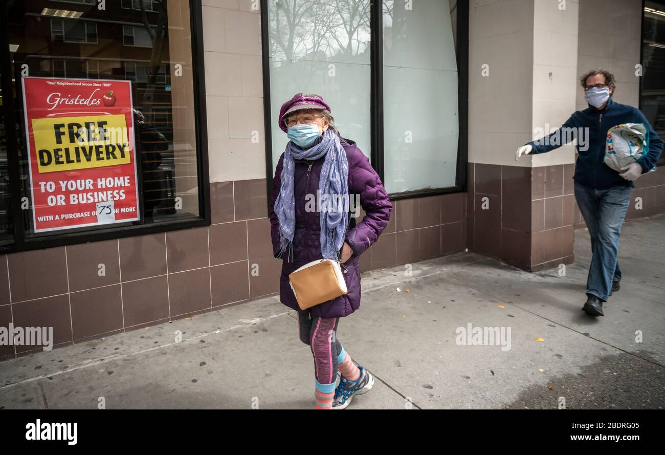 Una anciana camina con su máscara en Chelsea en Nueva York el sábado 4 de abril de 2020 debido a COVID-19. (© Richard B. Levine) Foto de stock