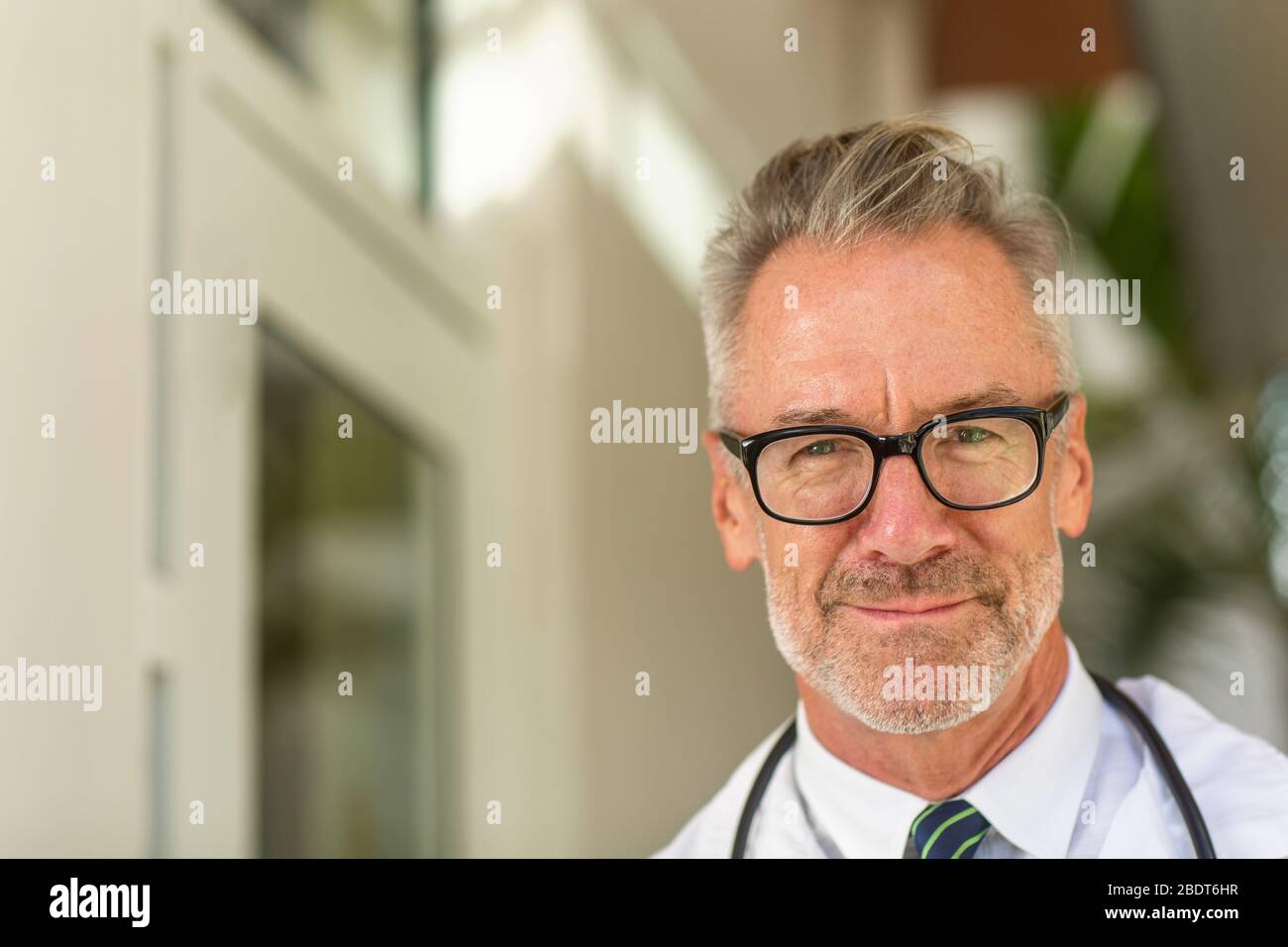 Retrato de un maduro guapo doctor en un consultorio médico. Foto de stock