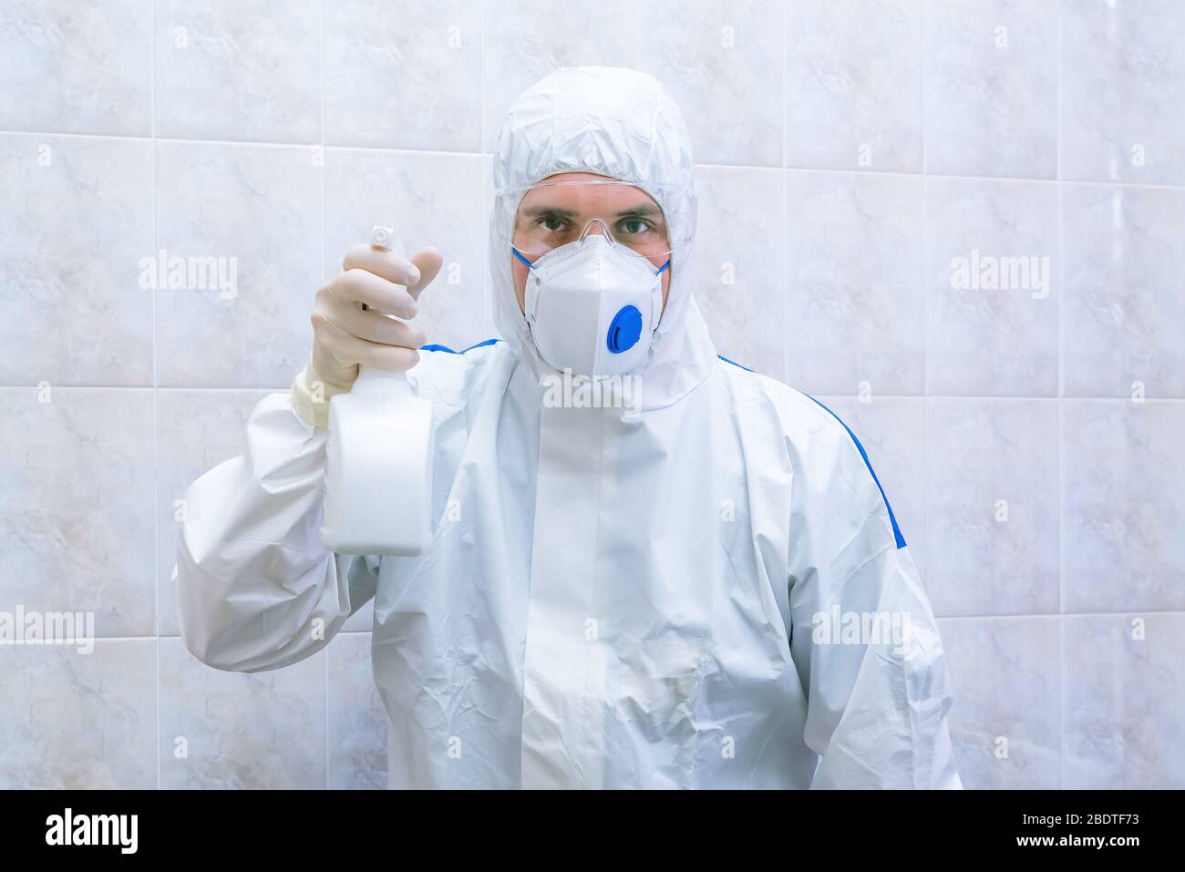 Médico en traje protector con aerosol antiséptico en las manos durante el  período pandémico. Concepto de enfermedad epidémica. Enfoque selectivo  Fotografía de stock - Alamy