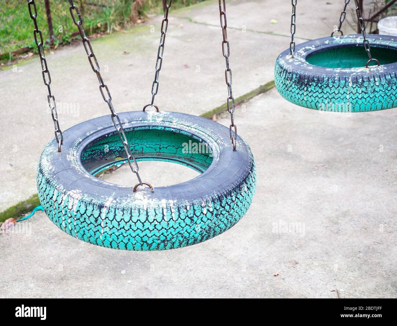 Dos columpios para niños hechos de una rueda de coche pintada con pintura  azul y colgando en cadenas Fotografía de stock - Alamy