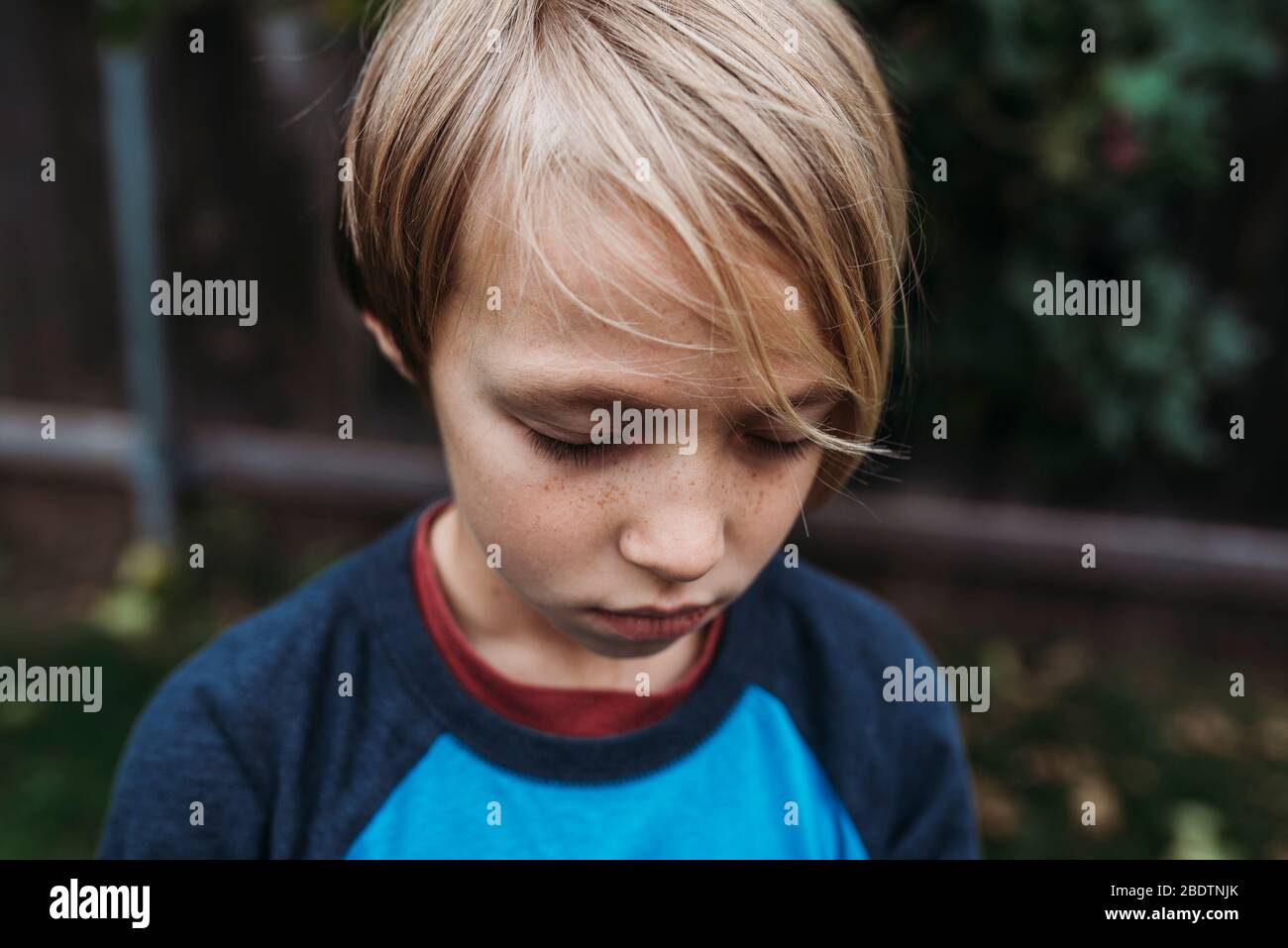 Primer plano de niño con los ojos cerrados y pecas Foto de stock