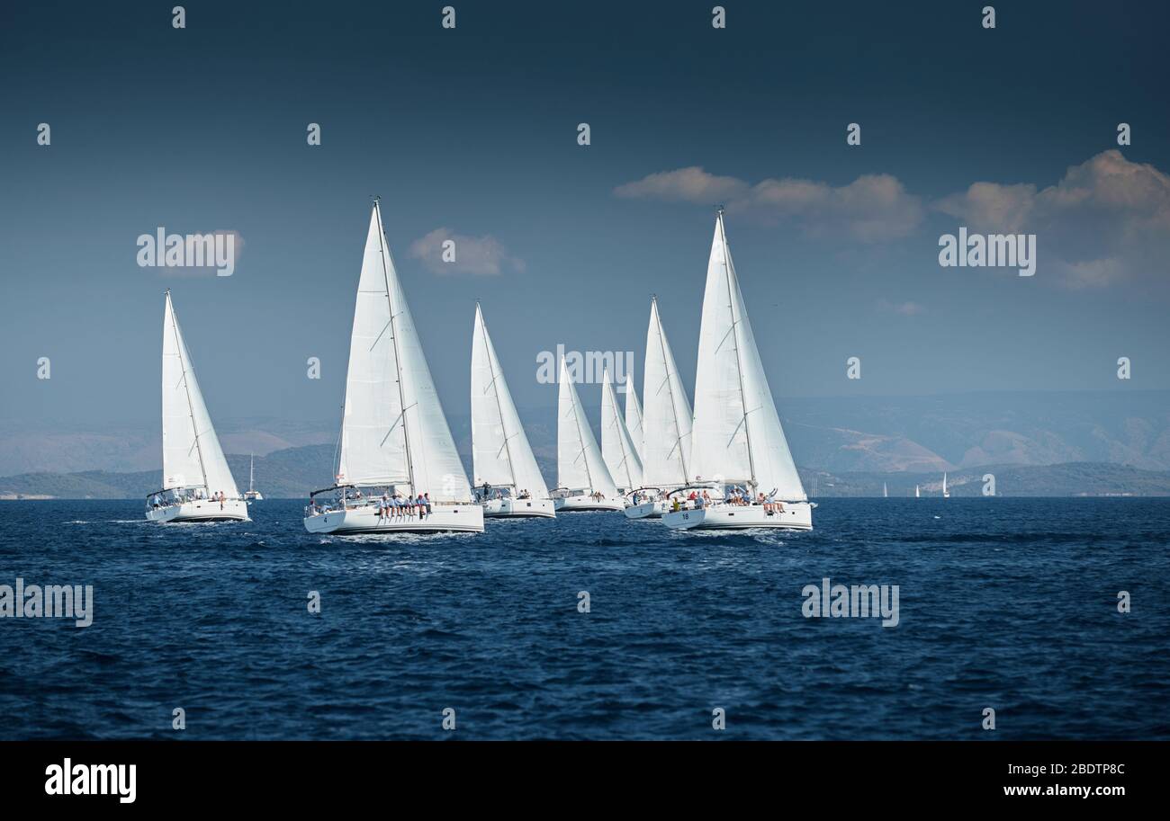 La carrera de veleros, una regata de vela, reflejo de velas en el agua, intensa competencia, el número de barcos es en popa, colores brillantes, la isla está en Foto de stock