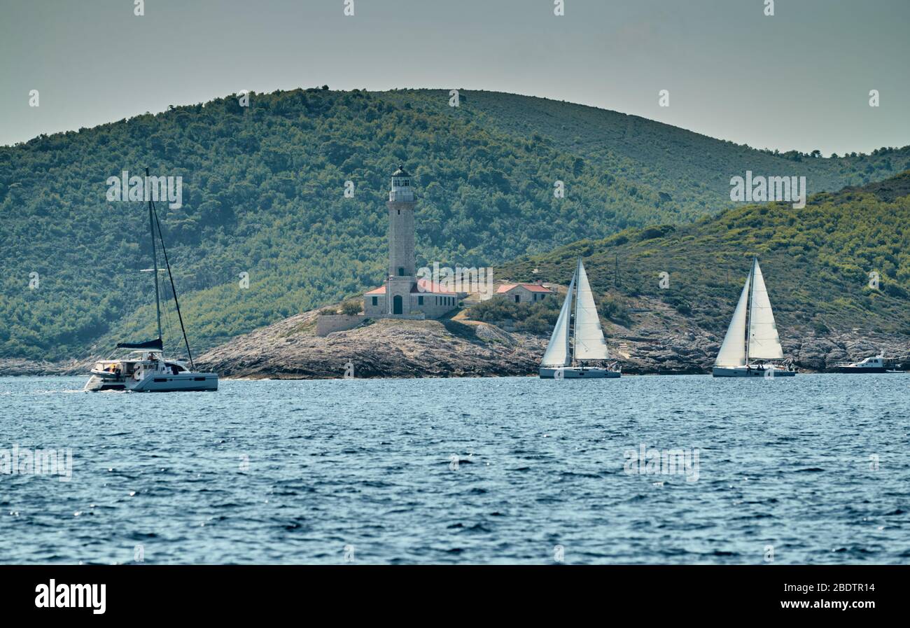 La carrera de veleros, una regata de vela, reflejo de velas en el agua, intensa competencia, el número de barcos es en popa, colores brillantes, la isla está en Foto de stock