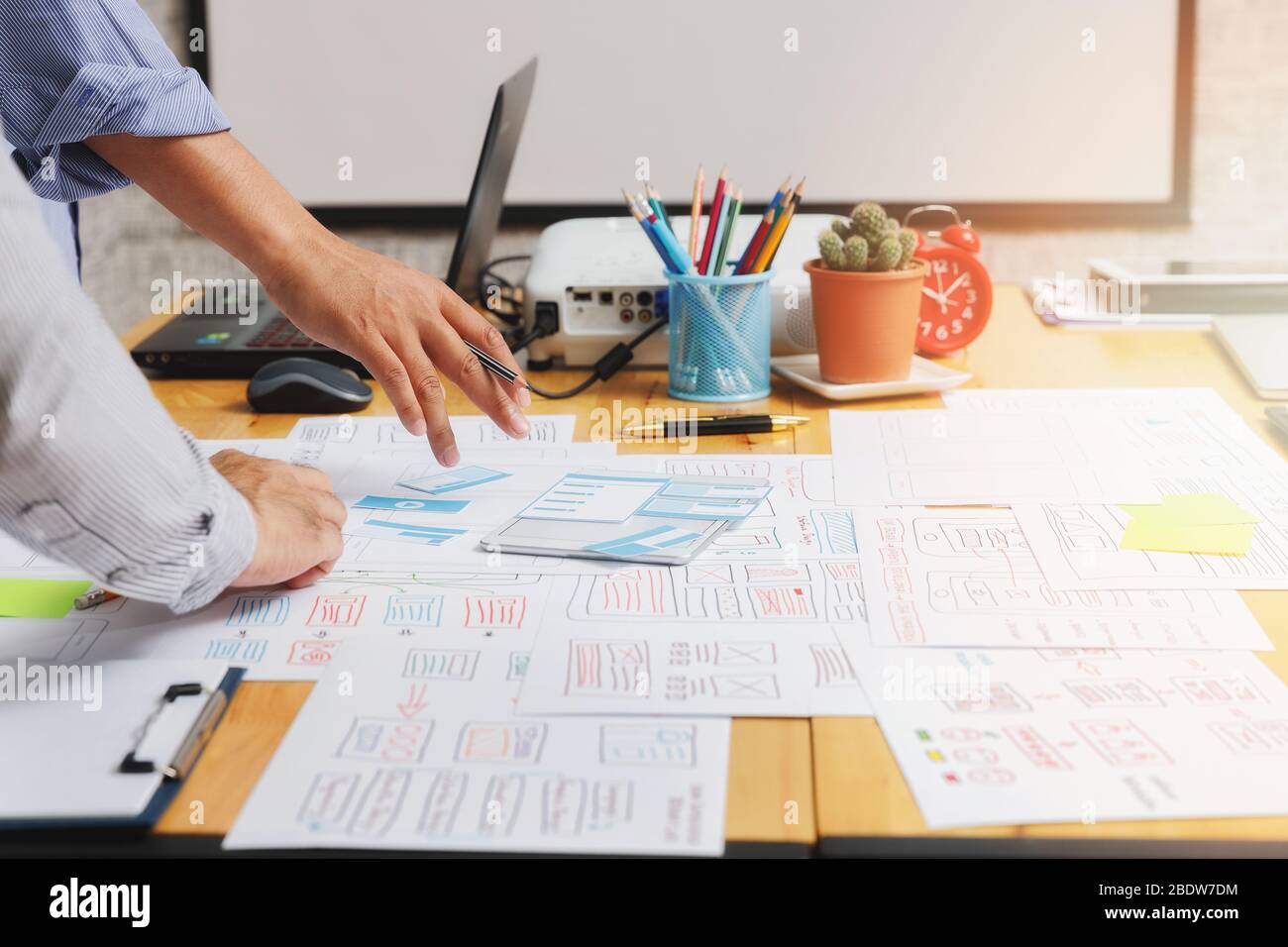 Diseñadores de UX o UI que diseñan en su proyecto prototipo de diseño de aplicaciones para smartphones. Foto de stock
