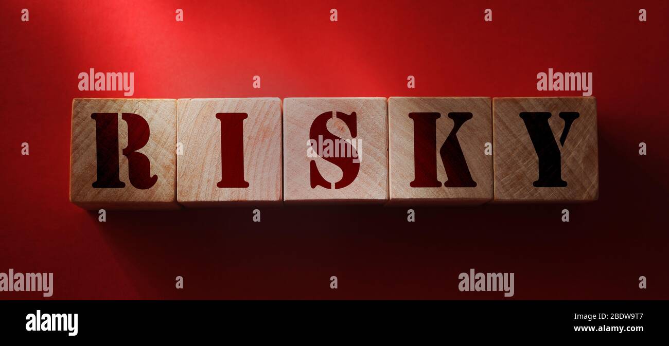 Palabra arriesgada sobre bloques de madera sobre fondo rojo. Activos de riesgo, riesgo financiero en concepto de inversión empresarial. Concepto de prevención del virus de Dangeruos Foto de stock