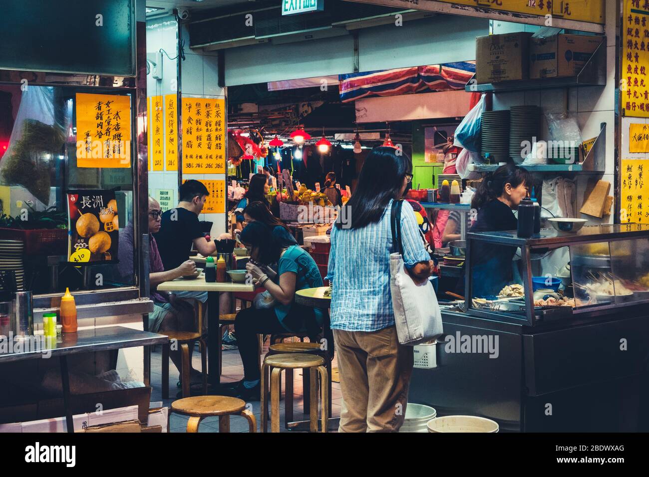 Hong Kong, noviembre de 2019: Personas comiendo en un restaurante al aire libre de comida callejera en Hong Kong por la noche Foto de stock
