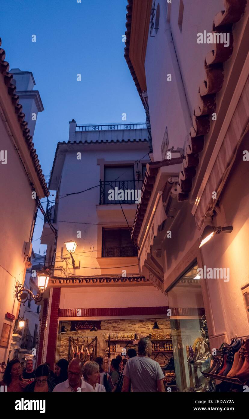 Gente de compras en una calle estrecha en el casco antiguo de Marbella, España. Foto de stock