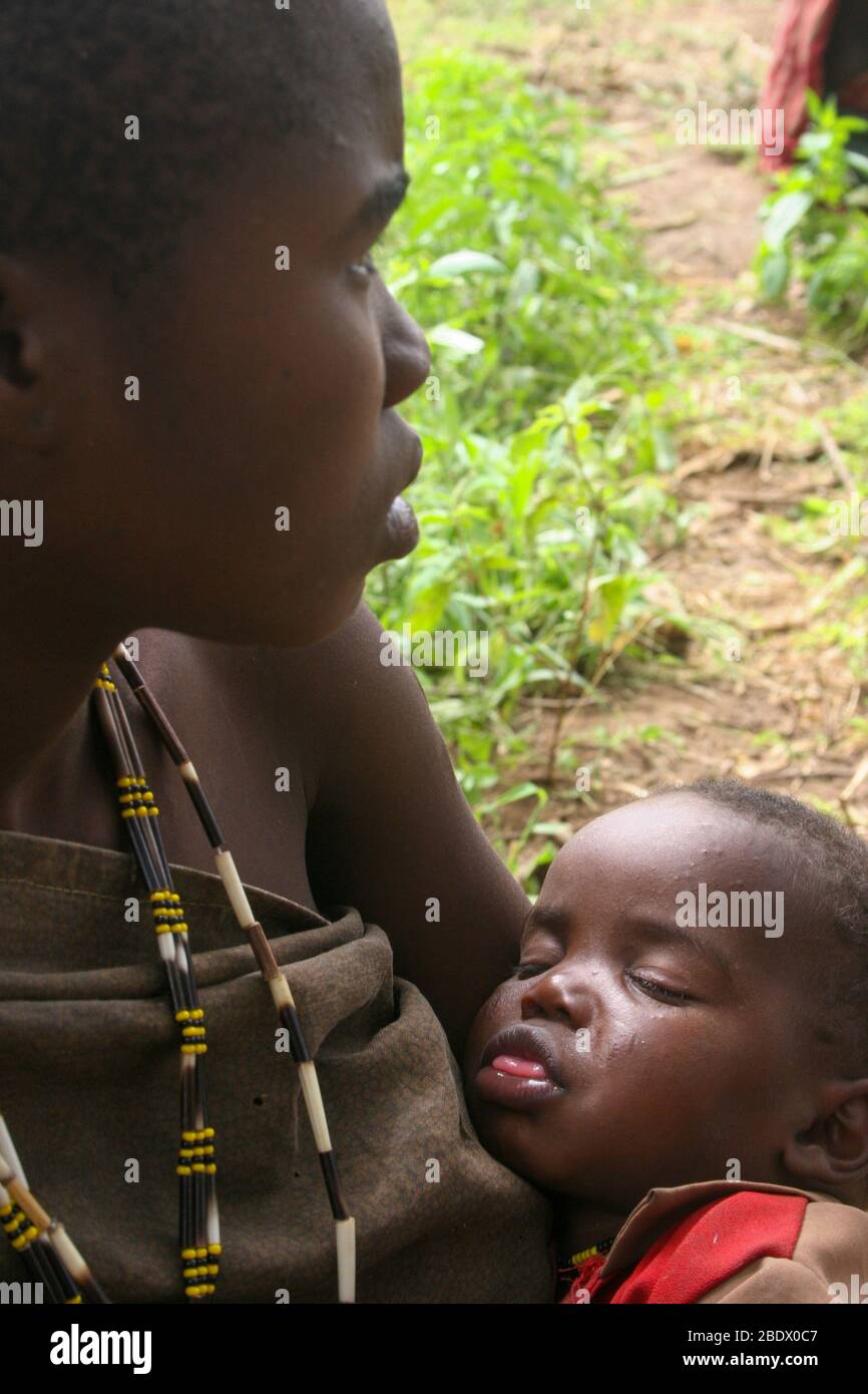 Retrato de una joven madre de Hadza con su bebé, Hadza o Hadzabe es una pequeña tribu de cazadores recolectores. Fotografiado en el Lago Eyasi, Tanzania Foto de stock