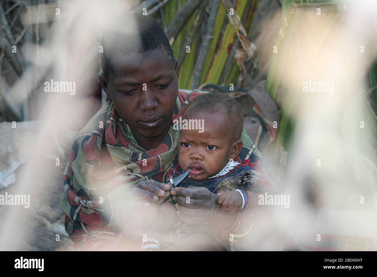 Retrato de una joven madre de Hadza con su bebé, Hadza o Hadzabe es una pequeña tribu de cazadores recolectores. Fotografiado en el Lago Eyasi, Tanzania Foto de stock