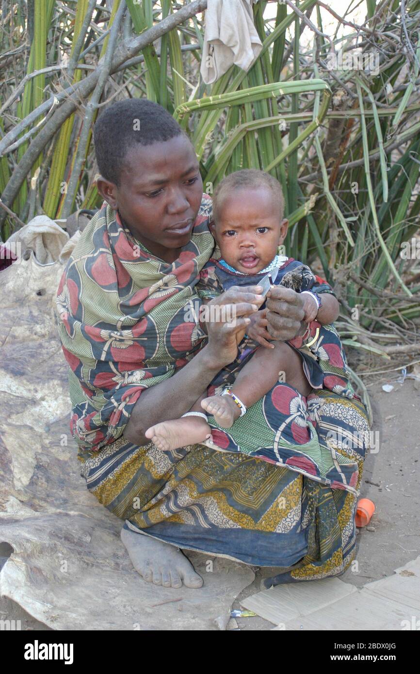 Retrato de una joven madre de Hadza con su bebé, Hadza o Hadzabe es una pequeña tribu de cazadores recolectores. Fotografiado en el Lago Eyasi, Tanzania Foto de stock