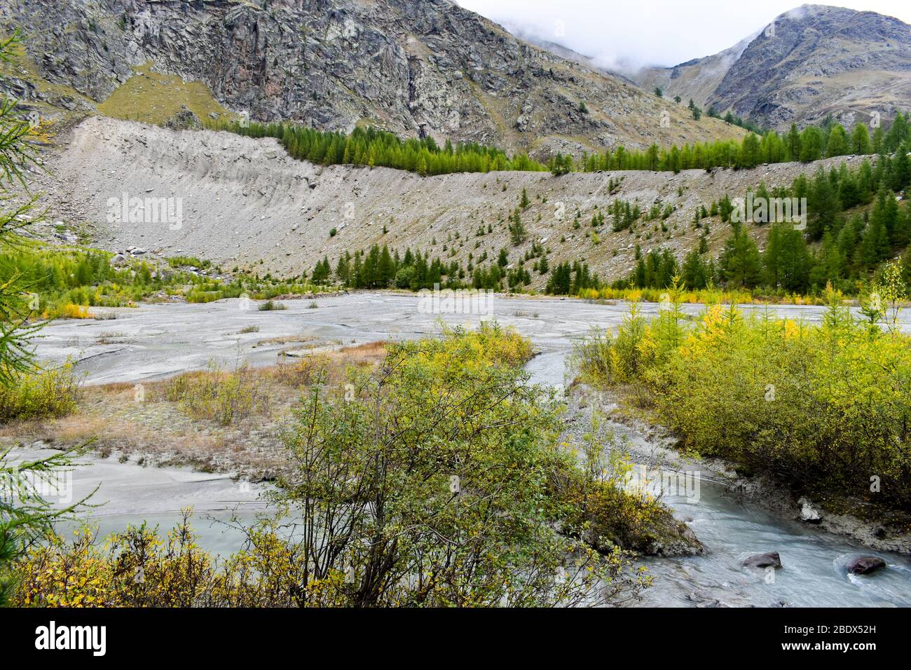 glaciar alpino creek con agua de deshielo nublado, que a veces se conoce como leche glacial. Foto de stock