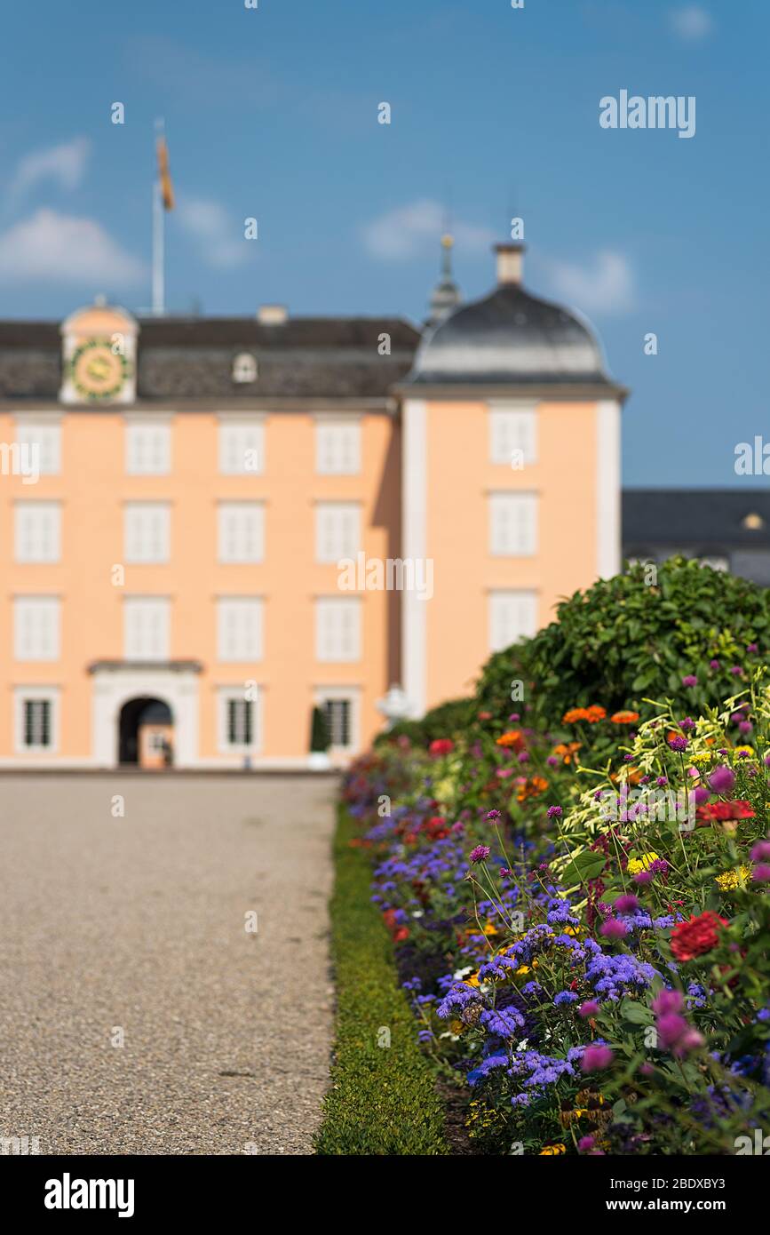 El Palacio Schwetzingen, visto a lo largo de una colorida cama de flores de primavera, Schwetzingen, Alemania. Foto de stock