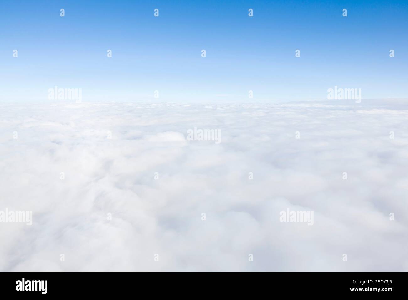 Vista aérea volando sobre las nubes en la atmósfera, representa el cielo, la Tierra y el medio ambiente Foto de stock