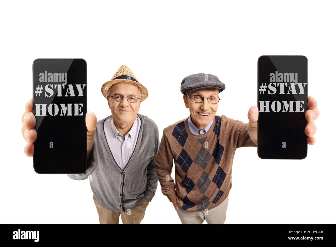 Dos hombres mayores mostrando un mensaje por teléfono diciendo quedarse en casa debido a coronavirus aislado sobre fondo blanco Foto de stock