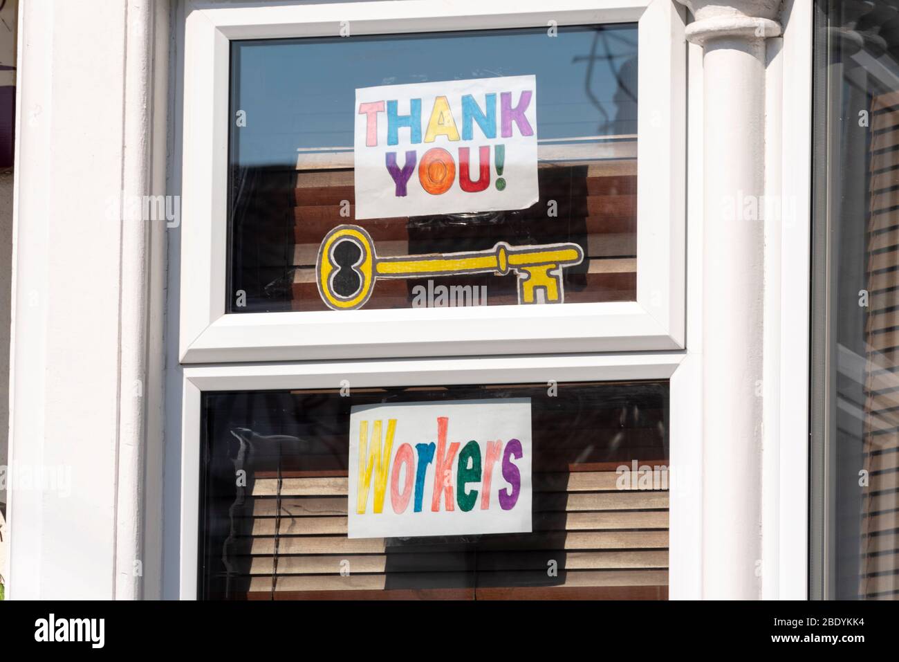 Gracias a los trabajadores clave firmar en la ventana de la casa durante el período de bloqueo de la pandemia del coronavirus COVID-19. Abertura en forma de llave Foto de stock