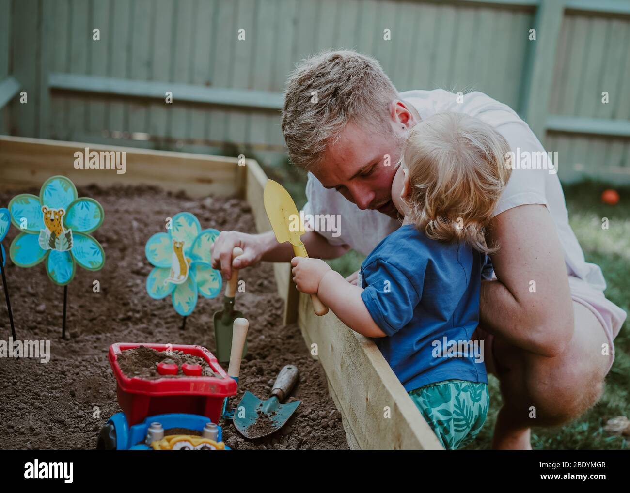 Niño pequeño niño pequeño jugando en el jardín con papá Foto de stock