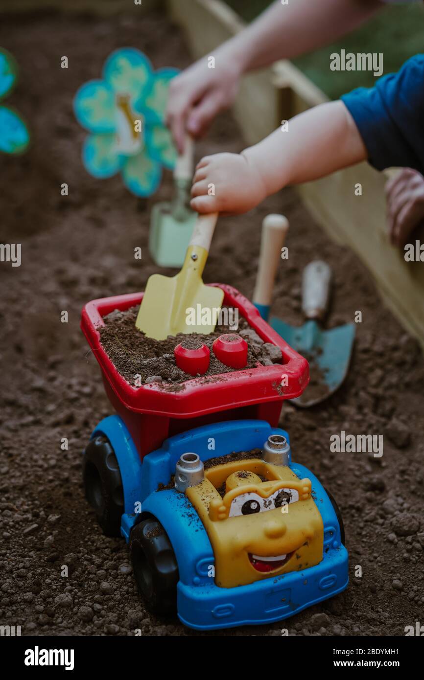 Niño pequeño niño pequeño jugando en el jardín con papá Foto de stock