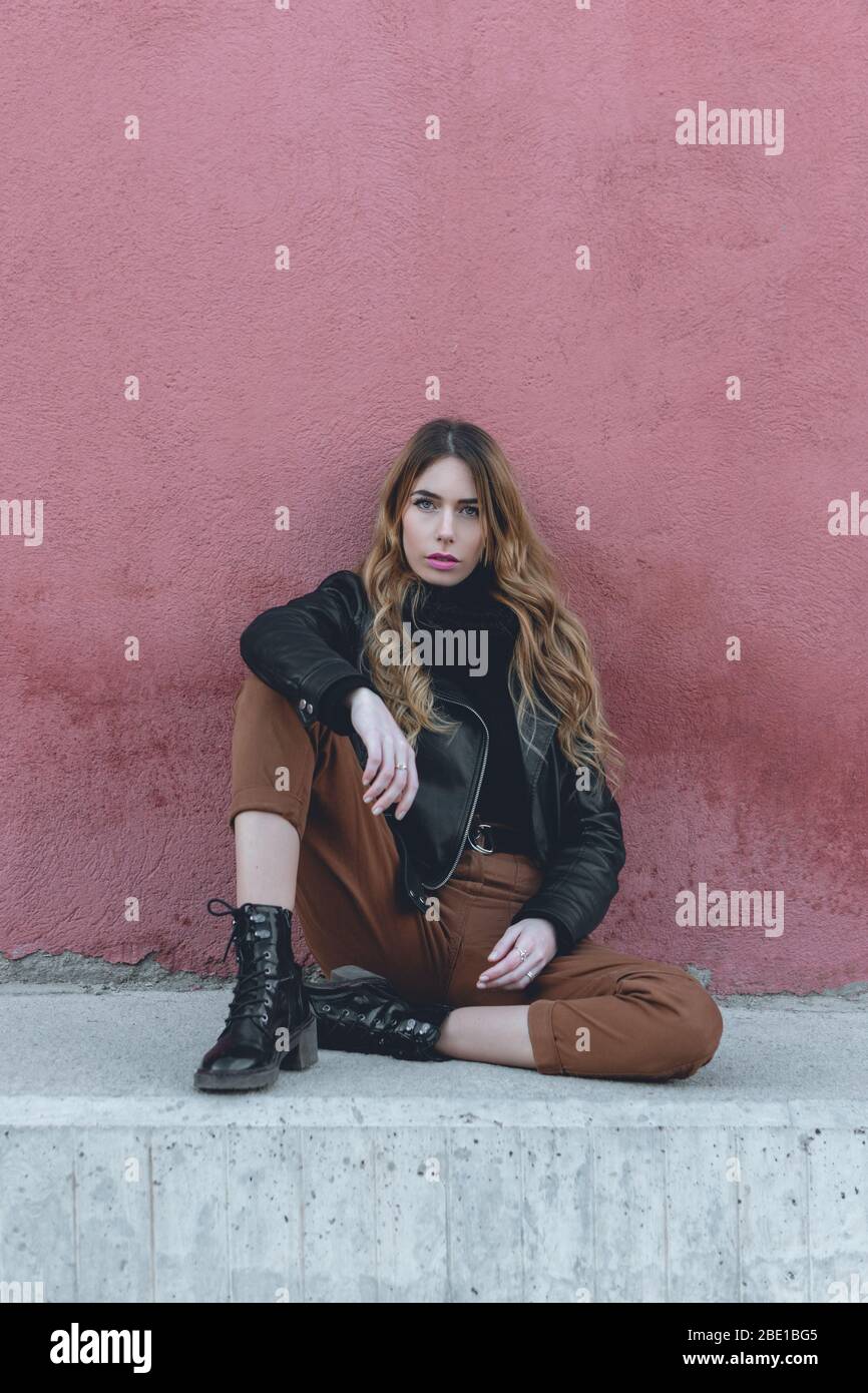 Joven modelo femenino profesional con ropa urbana para la colección de posando sentado en calle fotofoot para su cartera de modelos de stock - Alamy