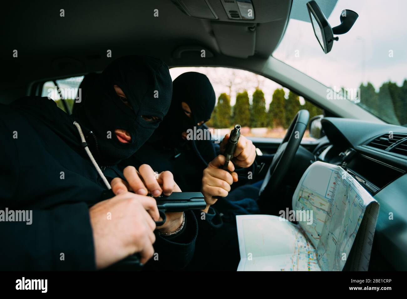 Ladrones de bancos, con sus máscaras en señalando el mapa preparado para  robar el banco,sentado en el coche y esperando el momento adecuado para  robar Fotografía de stock - Alamy