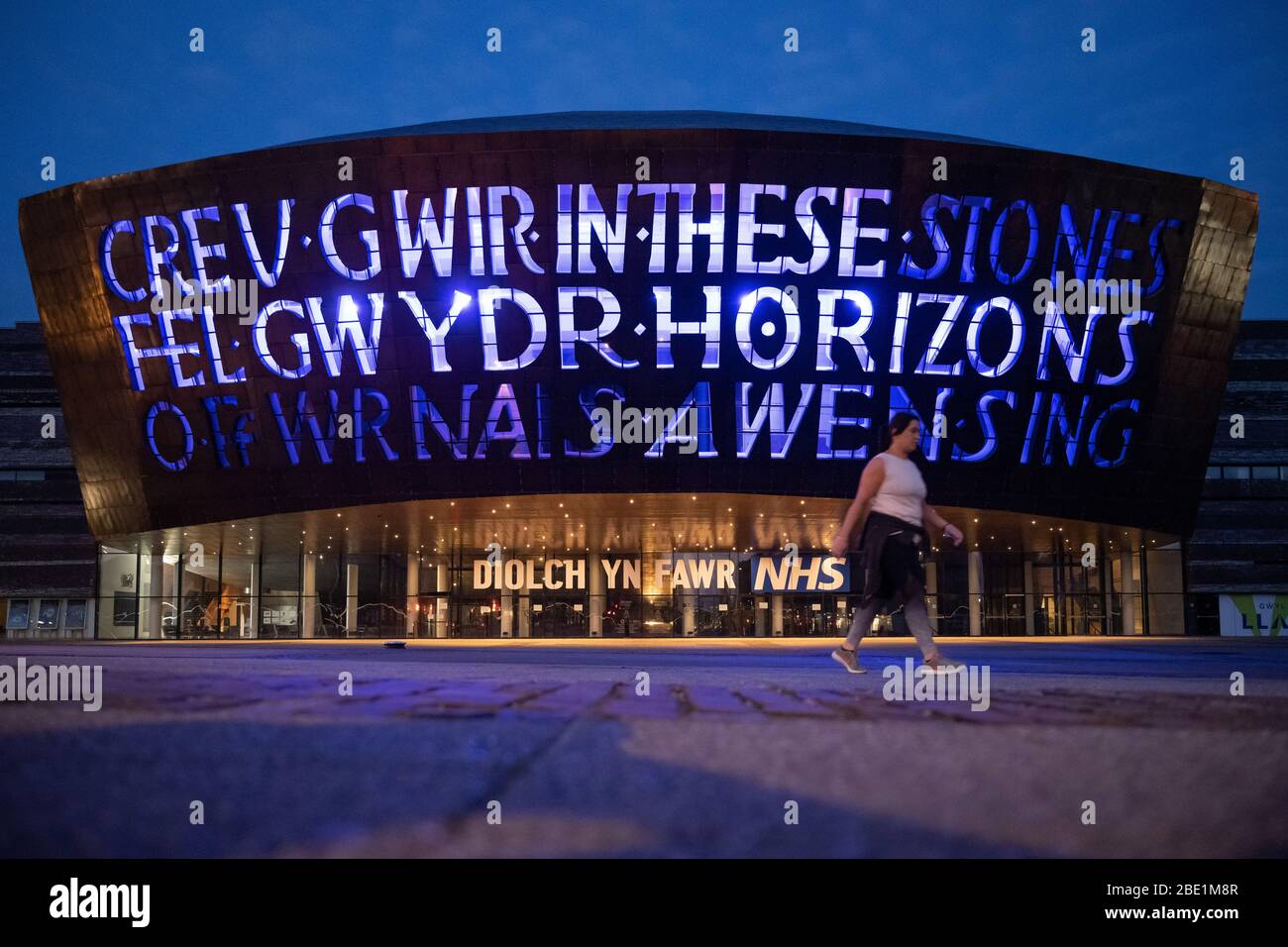 Una visión general del Centro del Milenio de Gales (WMC) se iluminó en azul en apoyo del NHS y otros trabajadores clave durante el bloqueo del coronavirus (COVID-19) Foto de stock