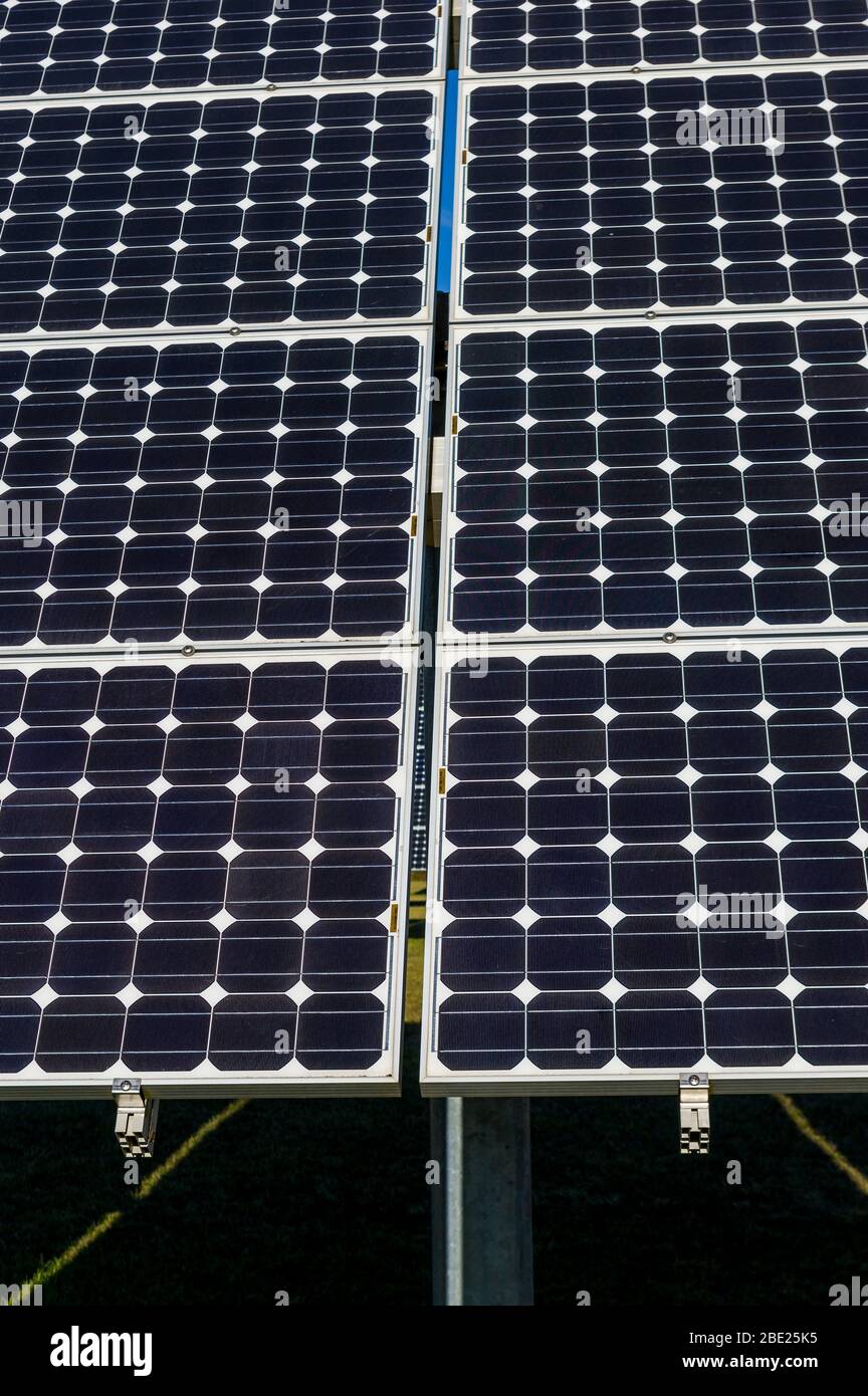 Primer plano, vista detallada de los paneles solares de una planta de energía solar en un cielo azul brillante y sin nubes Foto de stock