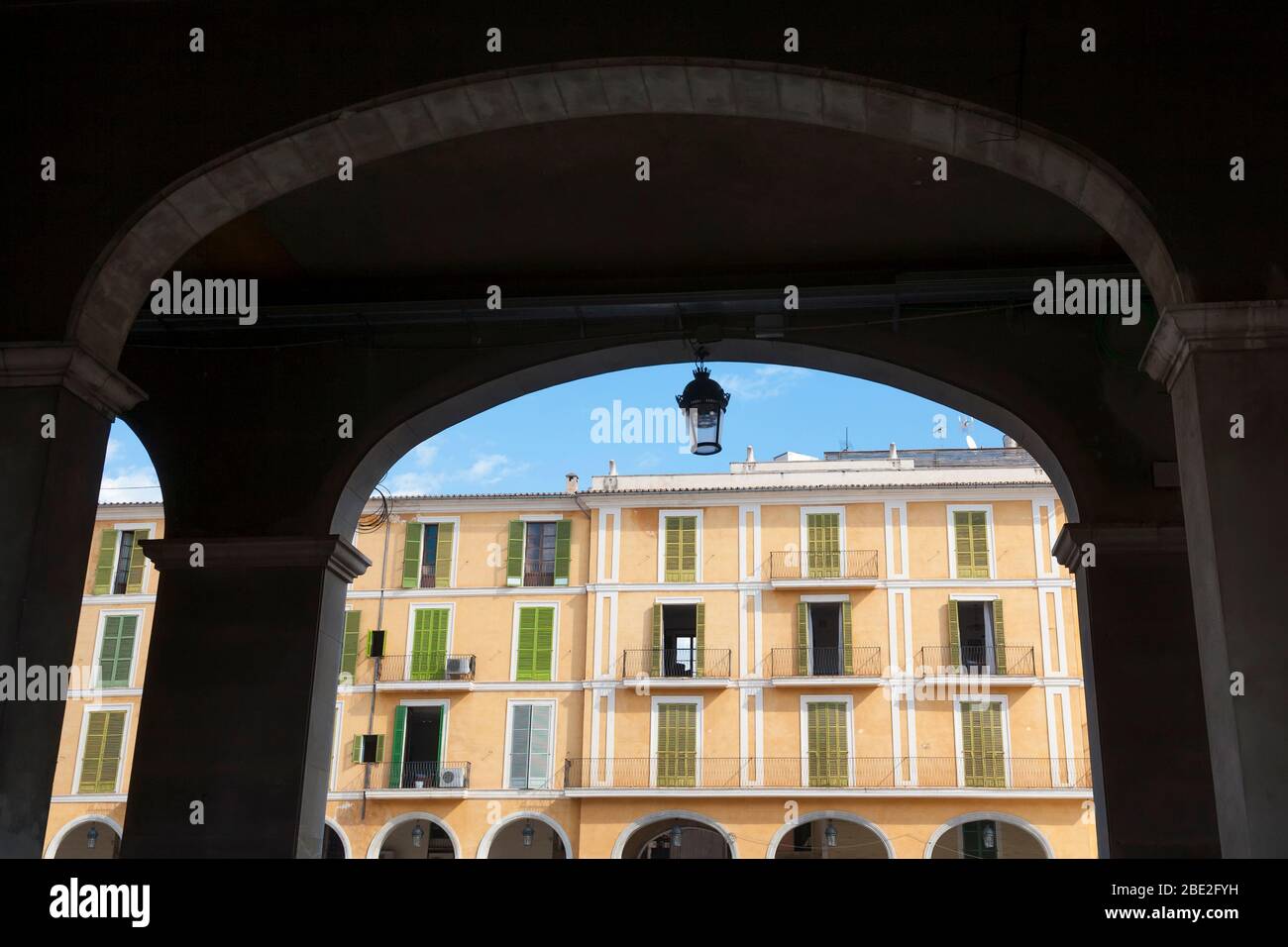 Tradicional bloque de apartamentos visto a través de arcos en Palma de Mallorca, España. Foto de stock