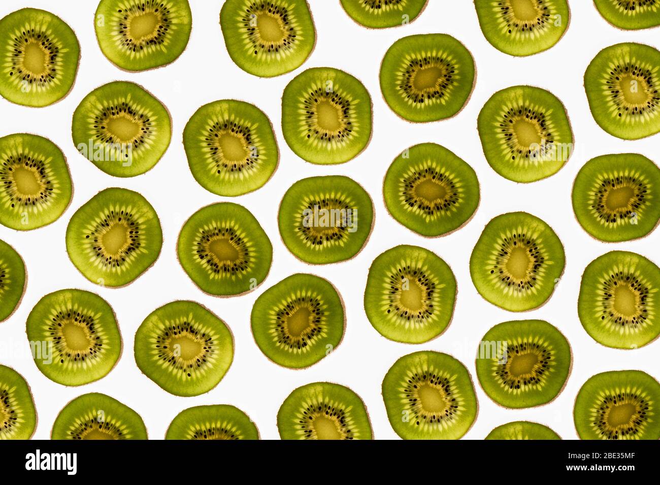 una hermosa imagen de un interesante patrón de rodajas de kiwi sobre un fondo blanco brillante, flaplay Foto de stock