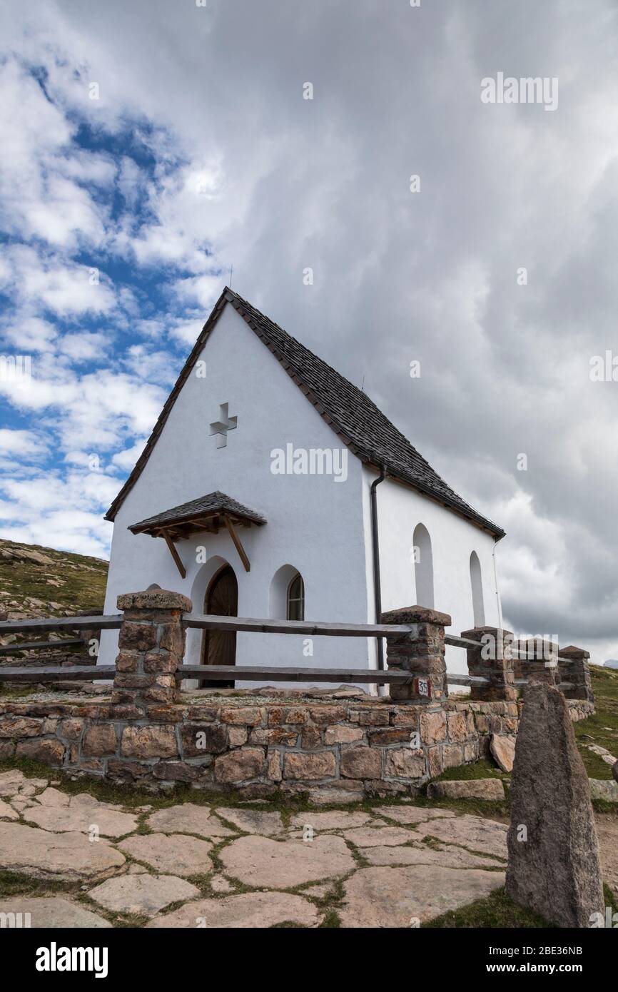 La pequeña capilla de la Santa Cruz cerca de la cumbre de la Alpa Alta Resciesa sobre Ortisei en los Dolomitas italianos. Foto de stock