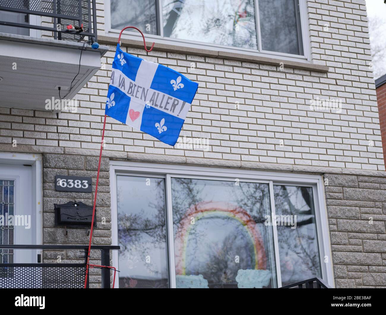 Casa con bandera de Quebec con el eslogan 'ca va bien Aller' y un corazón como mensaje de esperanza en Montreal durante la epidemia de CoVID19, con el arco iris dibujo i Foto de stock