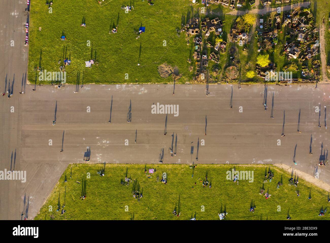 Berlín, Alemania. 11 de abril de 2020. La gente está de vuelta en Tempelhofer Feld durante la puesta de sol (los jardines comunitarios se pueden ver en la esquina superior derecha). Para frenar la propagación del virus de la corona, el gobierno alemán ha restringido considerablemente la vida pública. (Vista aérea con un drone) crédito: Christophe Gateau/dpa/Alamy Live News Foto de stock