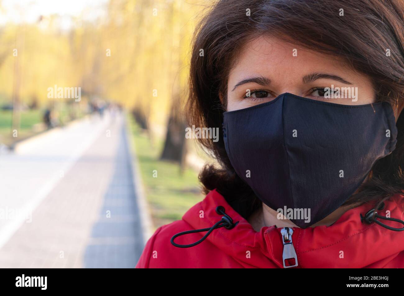 Retrato de una mujer con máscara negra hecha a mano. Cuarentena en 2020. Prevención del brote de coronavirus SARS-CoV-2 Foto de stock