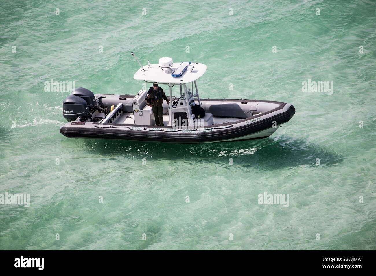 Un oficial de la Comisión de vida Silvestre de la Florida patrulla a lo largo de una playa cerrada durante la pandemia de COVID-19 Foto de stock