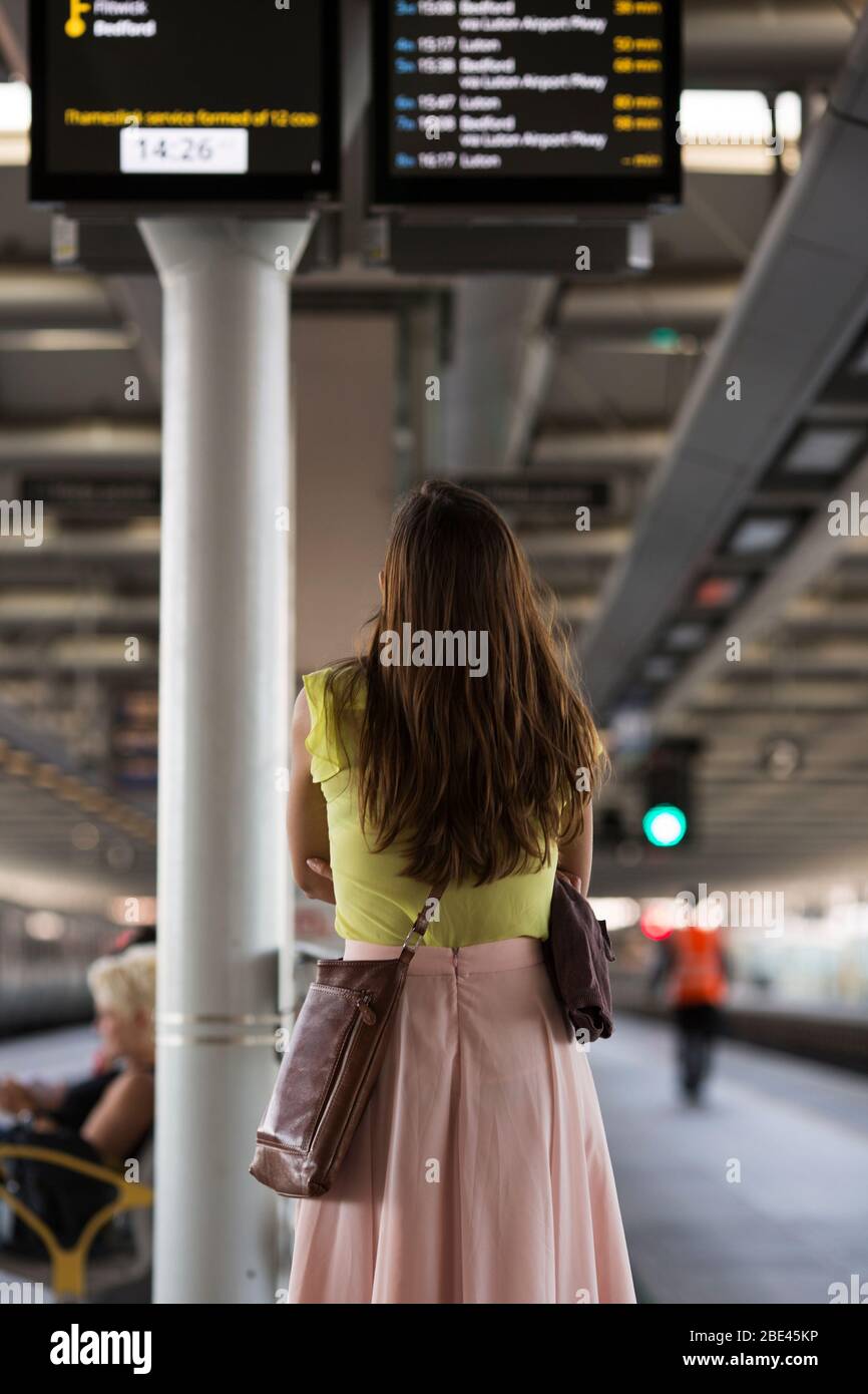 Una joven estudia el cartel de llegadas en la estación Blackfriars en Londres, Inglaterra, Reino Unido. Foto de stock