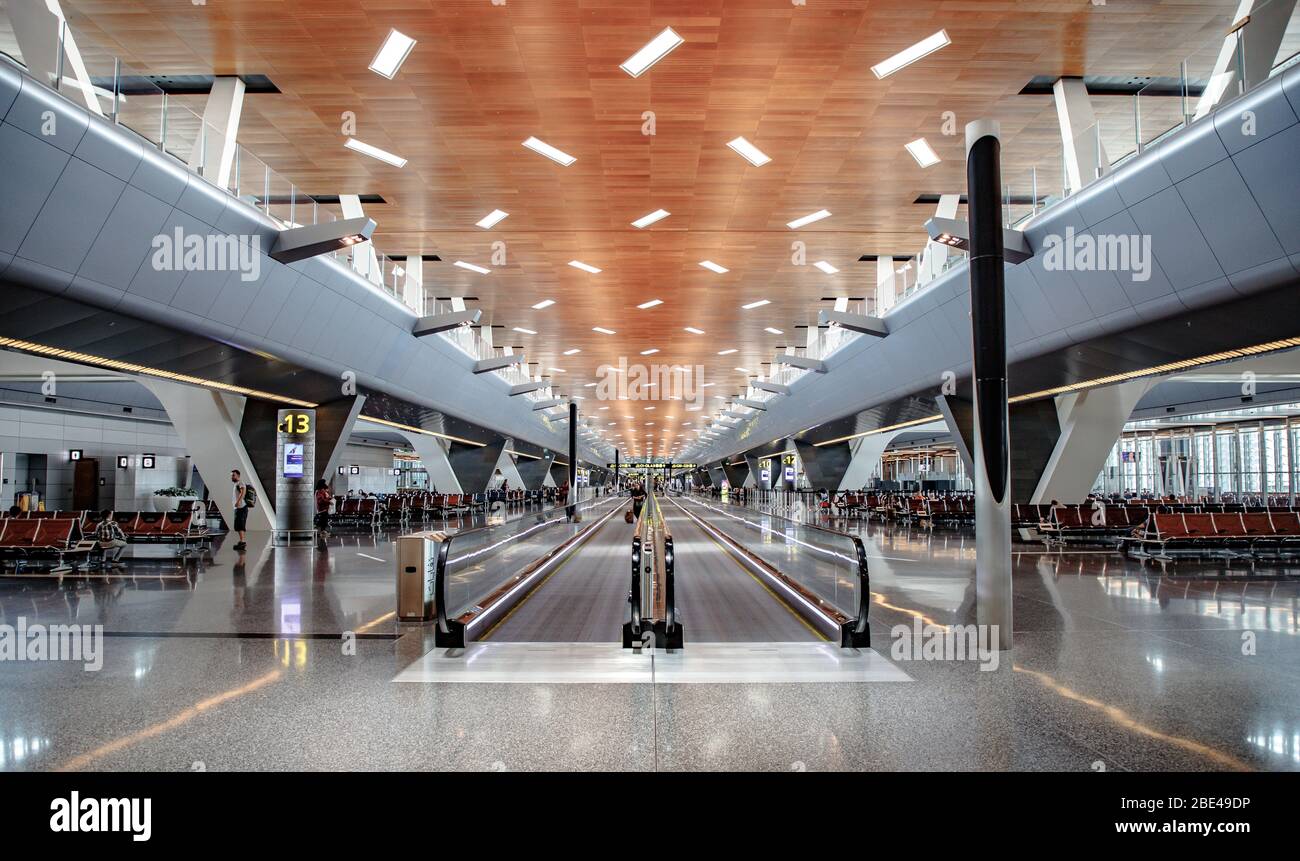 Escaleras mecánicas y puerta de embarque en una terminal del aeropuerto internacional de Hamad en Doha, Qatar Foto de stock