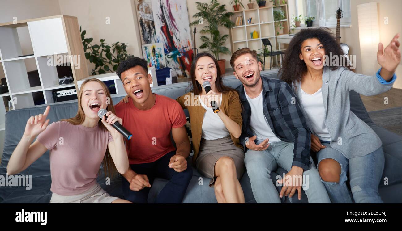 Entretenimiento en casa. Grupo de jóvenes amigos multiculturales felices  jugando karaoke en casa, cantando con micrófono, pasando un buen rato  juntos Fotografía de stock - Alamy