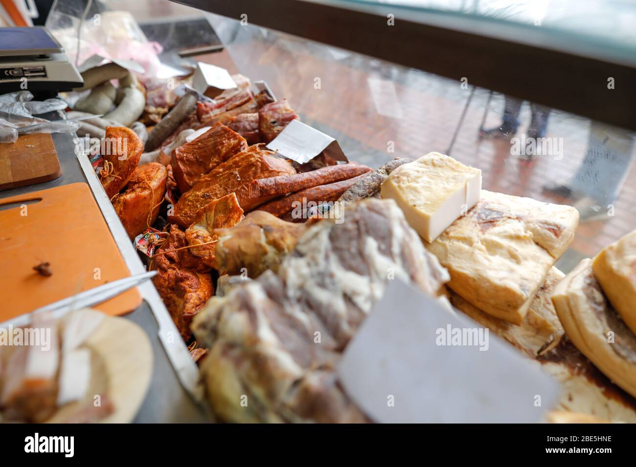 Imagen de profundidad de campo reducida (enfoque selectivo) con productos tradicionales rumanos de carne, principalmente de cerdo, en exhibición en un mercado. Foto de stock