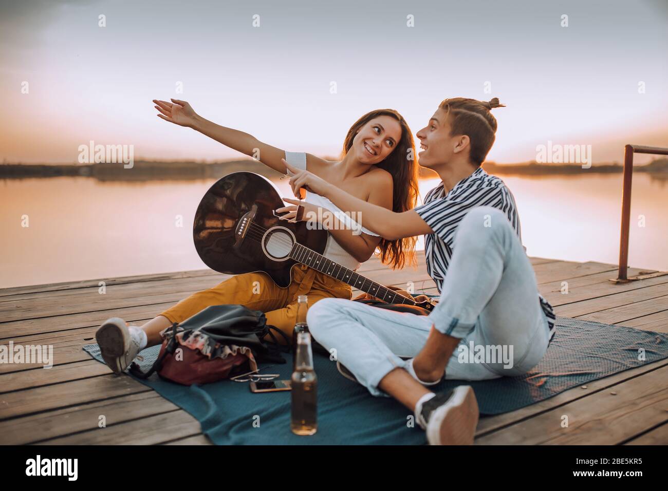 Feliz joven alegre pareja enamorada divertirse junto al río. Chica  mostrando algo interesante para su novio Fotografía de stock - Alamy