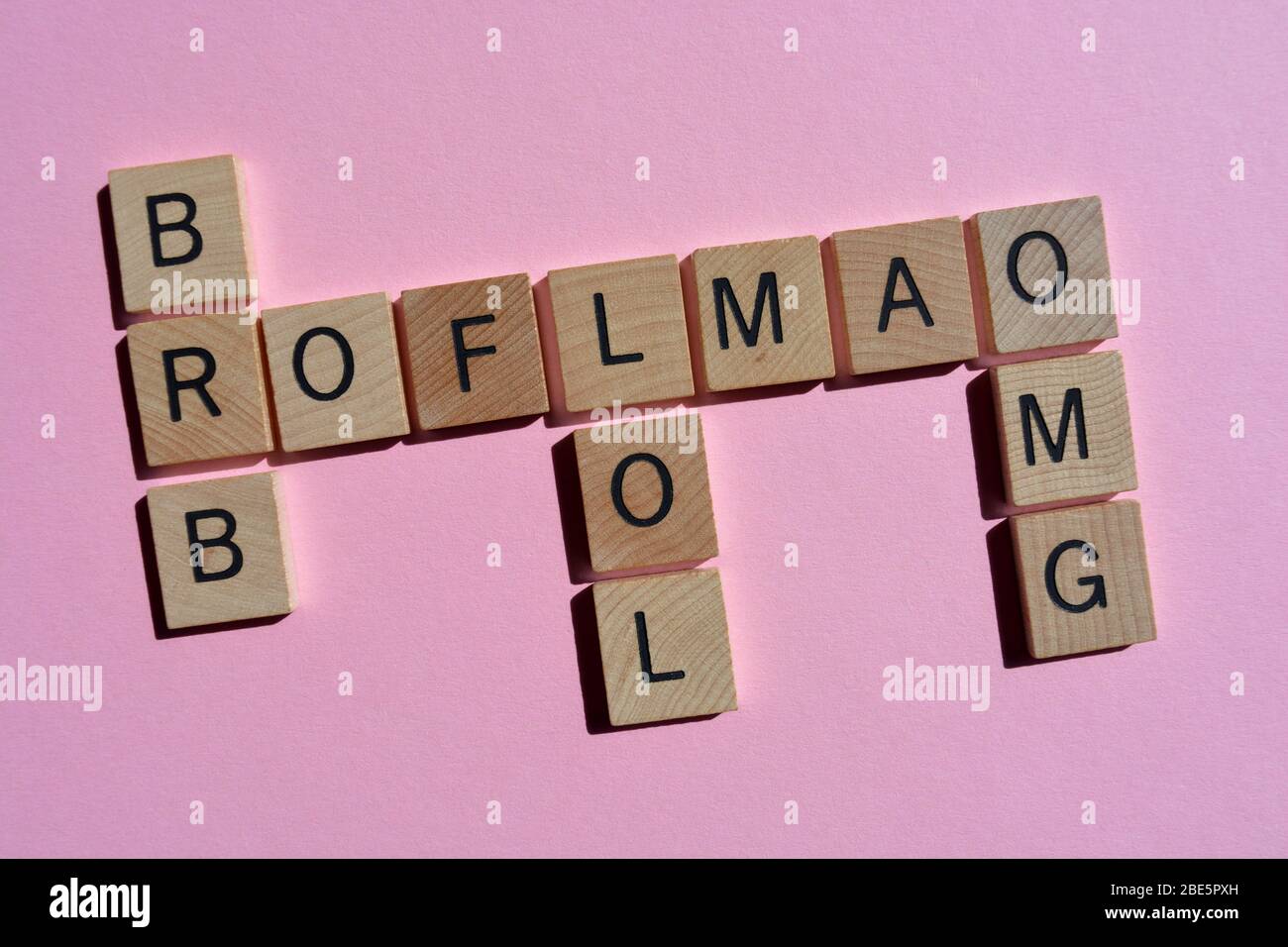 Internet slang incluyendo BRB, Be Right Back, y LOL, un montón de risas en un crucigrama sobre rosa Foto de stock