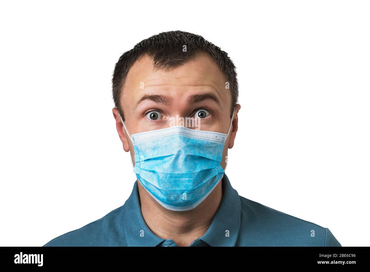 Hombre en una máscara médica con una expresión sorprendida en su rostro aislado sobre un fondo blanco. Concepto de cuarentena pandémica Covid-19 Foto de stock