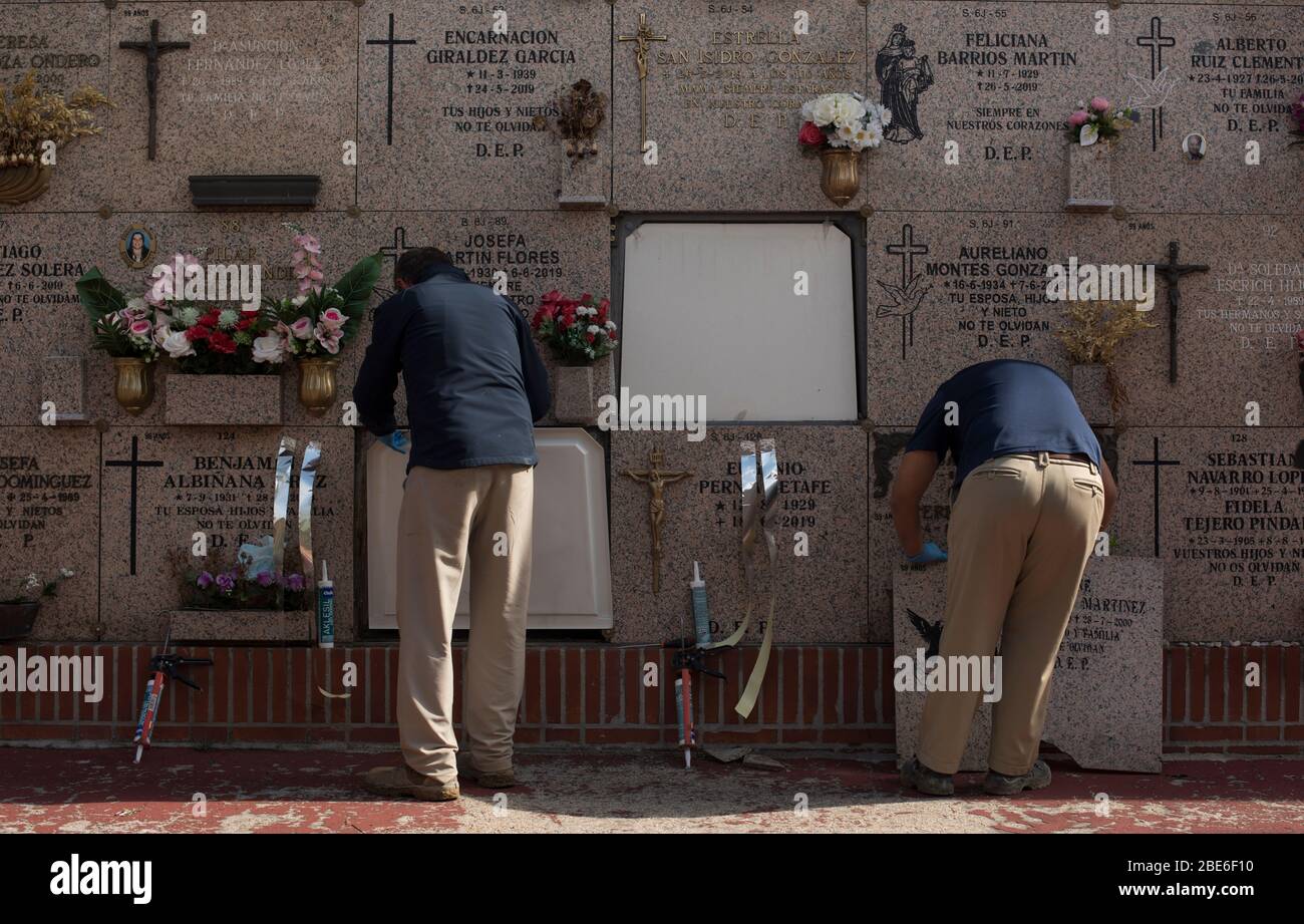 España - Madrid - 12 de abril de 2020 - trabajadores funerarios dispuestos a enterrar un ataúd en el Cementerio Sur de Madrid - las funerarias se han limitado a un máximo de tres familiares debido a la crisis sanitaria causada por el coronavirus. Foto de stock